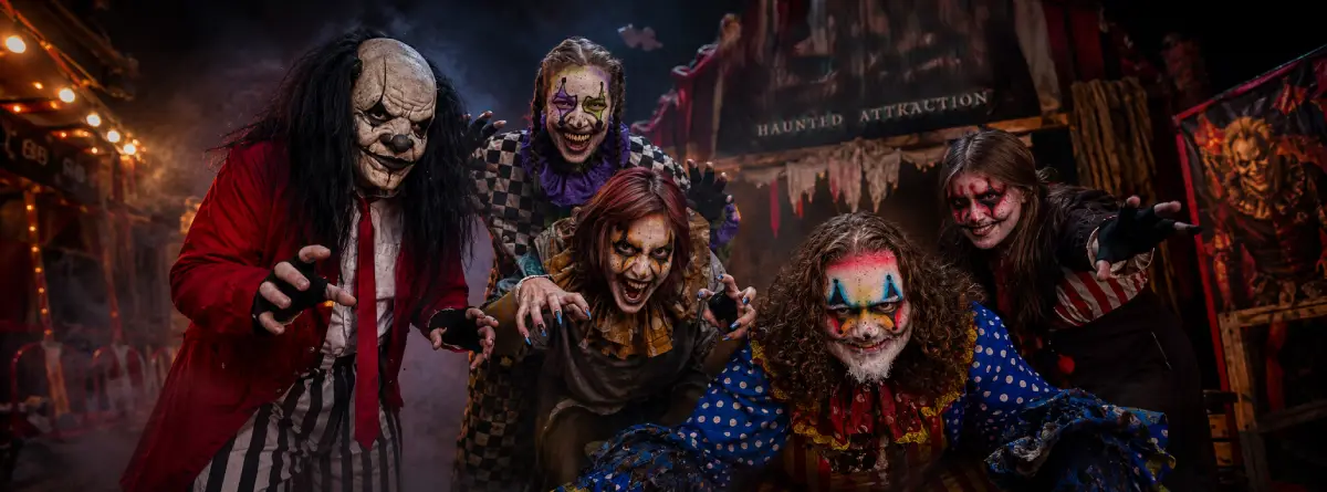 Four Scythes Haunted Attraction performers gathered outside a haunted carnival attraction